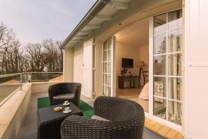 d'une terrasse avec 2 chaises et une table sur un balcon. dans l'établissement Chambre d'Hôtes La Courbe, à Lugan