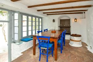 a dining room with a wooden table and blue chairs at Hydra town, Relaxing patio Panoramic sea view in Hydra