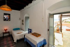 two beds in a room with a window at Hydra town, Relaxing patio Panoramic sea view in Hydra