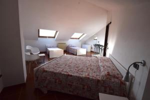 a bedroom with a bed and a chair and two windows at Case Vacanze Malonghe in Deiva Marina