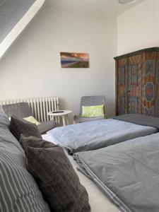 1 Schlafzimmer mit 2 Betten, einem Tisch und einem Stuhl in der Unterkunft Gästehaus Kleiner Wacholder in Bad Doberan