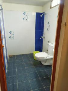 a bathroom with a toilet and a blue tile floor at SKY PARK HOTELS in Tiruppūr