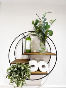 a round shelf with a bottle of wine and flowers at Luxury Belfast Stay in Belfast