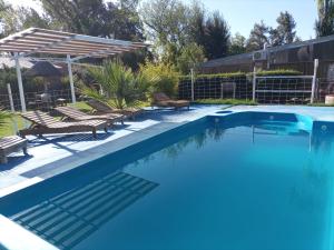 una gran piscina con sillas y sombrilla en Amanecer en Cuyo en San Rafael
