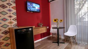 a kitchen with a small table and a tv on the wall at KONI's Studio Apartments in Tirana