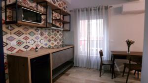 a kitchen with a desk and a table with a television at KONI's Studio Apartments in Tirana