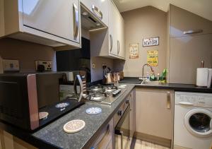 a small kitchen with a stove and a microwave at Modern Apartment Sherburn In Elmet in Sherburn in Elmet