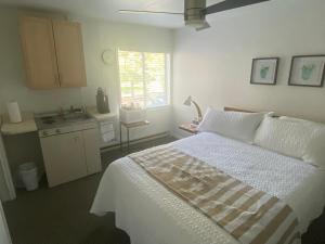 a bedroom with a white bed and a kitchen at The Summit Inn in Cloudcroft