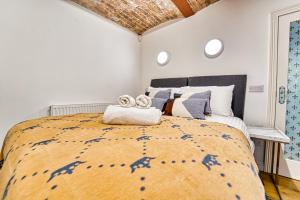 1 dormitorio con 1 cama grande y 2 toallas. en Guest Homes - The Basement On The Tything en Worcester