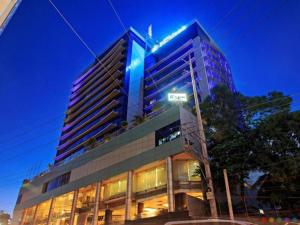 un edificio alto con un cartel en él por la noche en Cebu Parklane International Hotel, en Cebú