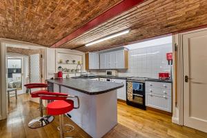 een keuken met een aanrecht en rode krukken. bij Guest Homes - The Basement On The Tything in Worcester