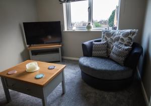a living room with a chair and a coffee table at Modern Apartment Sherburn In Elmet in Sherburn in Elmet