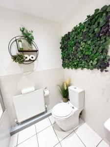 ein Badezimmer mit einem WC und einer grünen Pflanze an der Wand in der Unterkunft Luxury Belfast Stay in Belfast