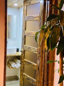 baño con puerta de madera y estante con toallas en Palmeras del Valle, en Santa Bárbara de Samaná