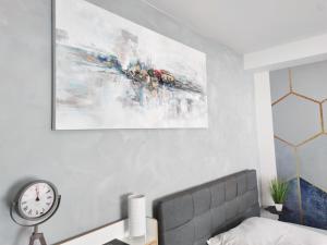 a bedroom with a bed and a clock on the wall at Business Style Apartment Ludwigshafen *Free Parking and WiFi* in Ludwigshafen am Rhein