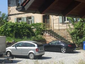 Stillvoll Wohnen mit Fahrradweg zum Festspielhaus في Heinersreuth: سيارتين متوقفتين أمام منزل