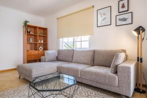 a living room with a couch and a glass table at Casa Flor do Campo in Calheta
