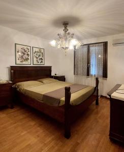 een slaapkamer met een bed en een kroonluchter bij Giuliana's House in Desenzano del Garda