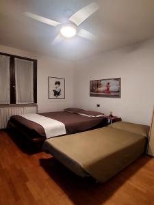 2 bedden in een kamer met een plafondventilator bij Giuliana's House in Desenzano del Garda
