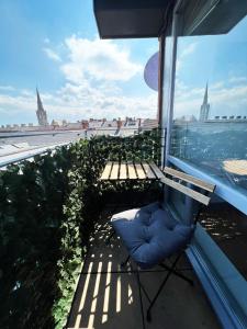 a chair on a balcony with a view of the city at Luxury Belfast Stay in Belfast