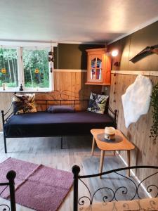ein Schlafzimmer mit einem Bett und einem Tisch in einem Zimmer in der Unterkunft Schnieder's Stuga in Harmånger