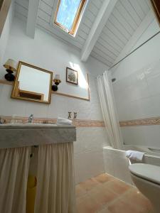 een badkamer met een wastafel, een spiegel en een bad bij Apartamento Pico de Alba in Benasque