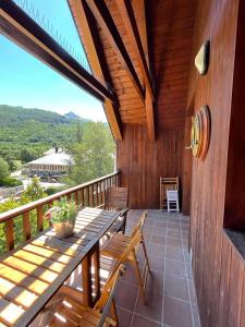 una terraza de madera con mesa y sillas de madera en Apartamento Pico de Alba, en Benasque