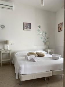 a white bedroom with a bed with two pillows at Book and Bed in Maglie
