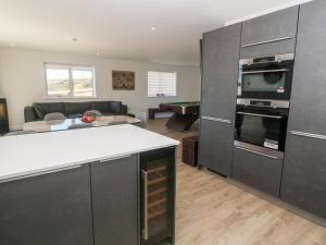 a kitchen with a counter and a living room at Sandy Cove in Penzance