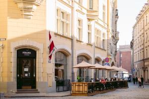 a restaurant with umbrellas in front of a building at Neiburgs Hotel in Rīga