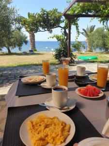 a table with plates of food and drinks on it at Afroditi Beach in Gerakini +48 photos