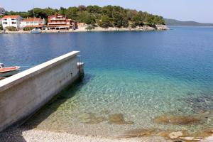 a dock in a body of water with a house at Apartments with WiFi Bozava, Dugi otok - 18916 in Božava