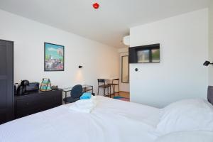 a bedroom with a white bed and a desk at DOMINIUM CITY SUITES in Dubrovnik
