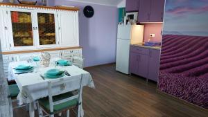 a kitchen with a white table and purple cabinets at Vila Largo in Donja Mala