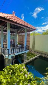 a swimming pool with a gazebo and a house at Juda Homestay in Banyuwangi