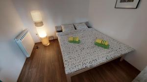 a small bedroom with a bed with two green pillows at Vila Largo 