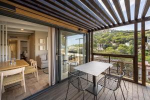 a room with a balcony with a table and chairs at TALAIA PLAZA ECORESORT BEGUR in Begur