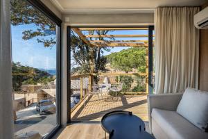 a living room with a couch and a large sliding glass door at TALAIA PLAZA ECORESORT BEGUR in Begur
