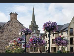 a church with flowers in front of a building at Exclusive Private double room, en-suite wet room Private entrance in Forres