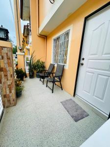a patio with chairs and a white door at AIRPORT GUESTHOUSE DAVAO in Davao City