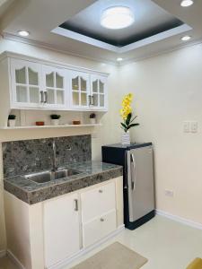 a kitchen with a sink and a refrigerator at AIRPORT GUESTHOUSE DAVAO in Davao City