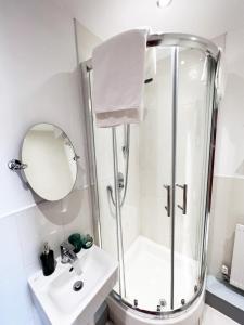 a white bathroom with a shower and a sink at Luxury Belfast Stay in Belfast