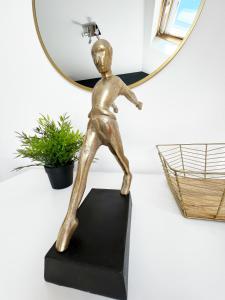 a bronze statue of a running man in front of a mirror at Luxury Belfast Stay in Belfast