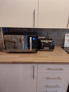 a microwave sitting on top of a kitchen counter at Stewarton apartments in Stewarton