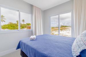 um quarto com uma cama azul e 2 toalhas brancas em SA06 Excelente Casa 5 Quartos - Reserva de Sauípe na Costa do Sauípe