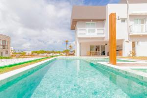 una piscina frente a una casa en SA06 Excelente Casa 5 Quartos - Reserva de Sauípe en Costa do Sauipe