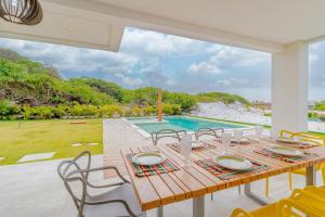 una sala da pranzo con tavolo e piscina di SA06 Excelente Casa 5 Quartos - Reserva de Sauípe a Costa do Sauipe