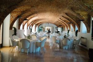 un comedor con mesas y sillas y un techo lleno de arcos en RELAIS CASCINA ERA, en Sandigliano