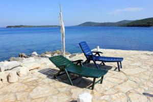 two chairs and a table next to the water at Secluded fisherman's cottage Zman, Dugi otok - 19000 in Žman