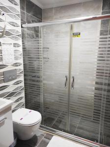 La salle de bains est pourvue d'une douche en verre et de toilettes. dans l'établissement Amasra Sunrise Otel, à Bartın